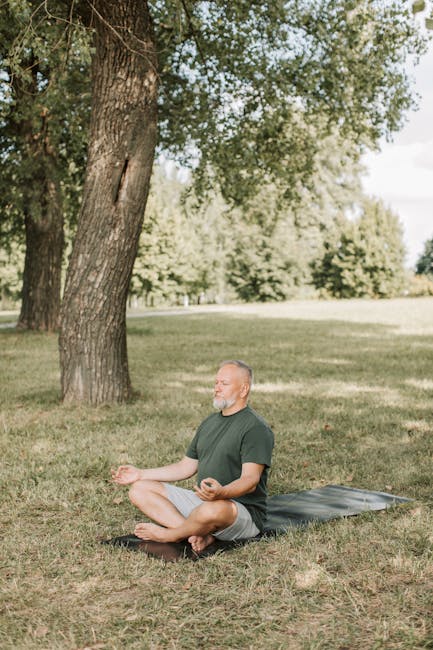Person sitting cross-legged on a yoga mat with eyes closed, embodying calmness.